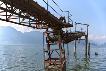 Old rusty structure with conveyor belt at Lake Maggiore in Italy.