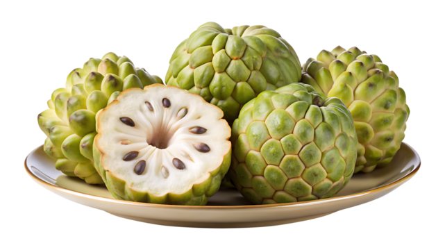 Ripe custard apples arranged on a plate, one sliced in half to show seeds