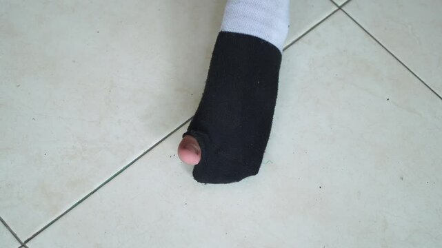The boy was wearing worn-out school socks with a hole in the big toe. His big toe was visible, sticking out of the sock.