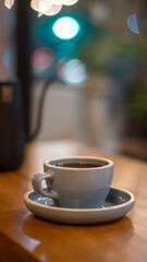 A cup of hot coffee or tea and teapot on wooden table with bokeh background	