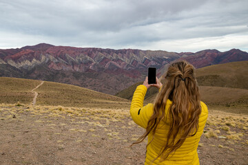 Woman taking a photo with her cell phone in Hornocal, Jujuy, Argentina.