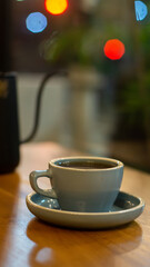 up of hot coffee or tea and teapot on wooden table with bokeh background