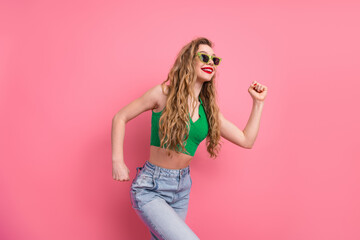 Joyful young woman posing in vibrant casual clothing against pink background showcasing fashionable...