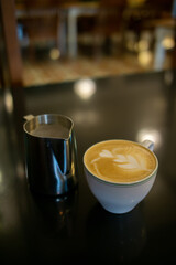 A cup of hot latte with froth art on café counter