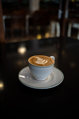A cup of coffee latte with froth art on the table	