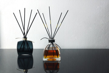 luxury aroma scent reed diffuser glass bottle is on glass table and white cement wall background in...