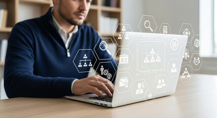 Man using laptop with digital icons overlayed for business management and organization tools at desk