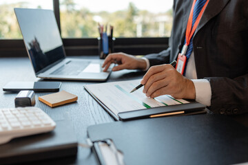 a businessman is reviewing accounting and financial statistics documents in his private office, the statistician prepares various charts and documents for a meeting