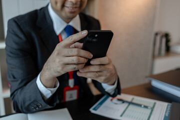 a businessman woks with a foreign company and uses a smartphone to help send and receive...