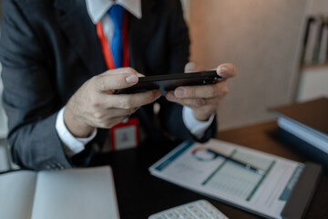 a businessman woks with a foreign company and uses a smartphone to help send and receive...