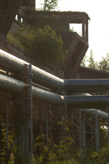 A large assortment of metal pipes is going down a steep hillside, possibly indicating some form of...
