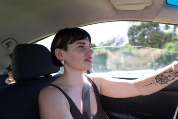 Fototapeta premium Young woman driving car wearing seatbelt and smiling