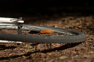 This image presents a closeup view of a bicycle wheel resting on the ground, showcasing the details...