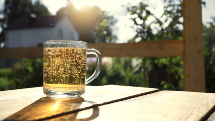 Glass cup with lemonade and splashes on a sunny summer day