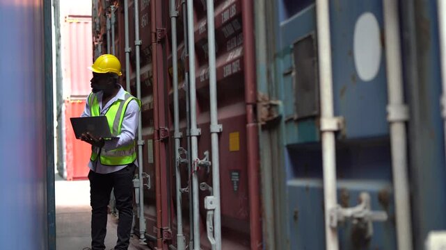 Industrial Engineers african american working with laptop computer checklist Inventory containers box in Shipping Cargo Container warehouse Terminal Depot. black dockers inspecting outdoors
