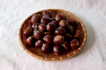 Raw chestnuts in a bamboo basket.