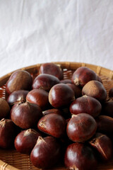 Raw chestnuts in a bamboo basket.