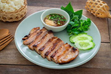 Grilled pork neck and thai spicy dipping sauce on plate served with sticky rice