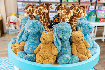  Jellycat brand stuffed giraffes, bunnies, and teddy bears on display in a shop