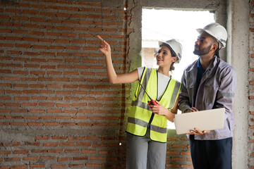 Two Engineer builder. Foreman use notebook computer and walkie talkie working in construction site.	