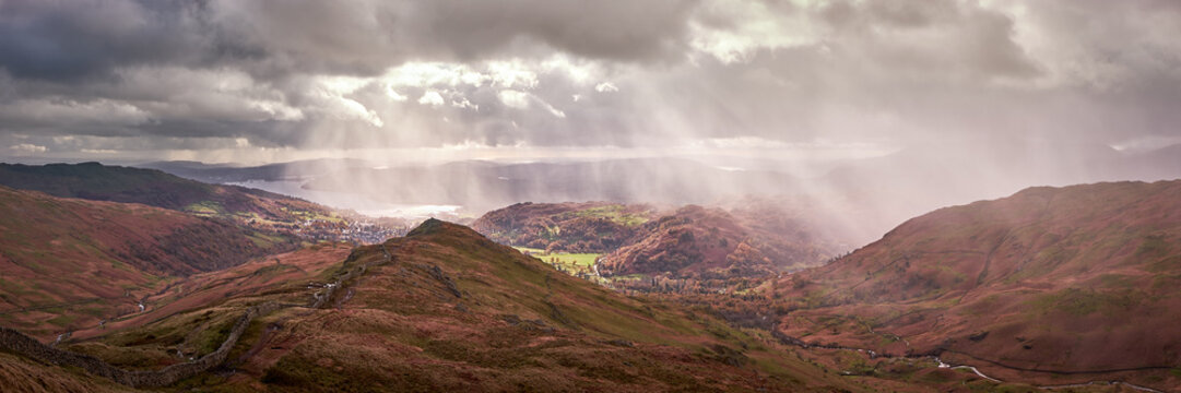 Panorama of shafts of sunlight over Ambleside and Windermere seen on the descent from High Pike, on the Fairfield Horseshoe, Lake District, UK