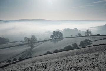 Early morning mist lying in the Derwent Valley near Calver, seen from fields above Froggatt, Peak District, UK
