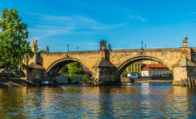 Obraz premium A view from the Vltava river down the west bank approaching the Charles bridge from the southern side in Prague in springtime