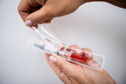 Nurse opening sterile syringe package for injection