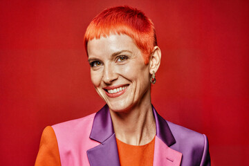A radiant portrait of a smiling woman with vibrant red hair