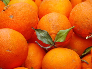 A bunch of oranges with a leaf on top