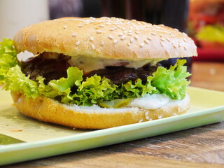 A sandwich with lettuce and meat on a green plate