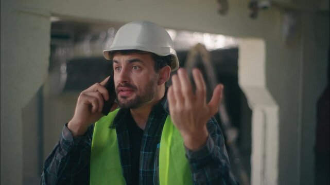 Irritated angry Caucasian man builder foreman arguing speaking mobile phone in construction contractor male technician shouting smartphone engineer architect guy disagreement problem conflict building