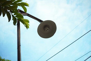 A lamppost angled upward against a blue sky