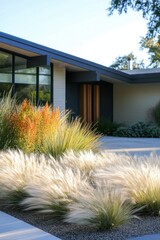 In a bright and sunny neighborhood, a contemporary home showcases modern landscaping that prominently features vibrant and colorful ornamental grasses