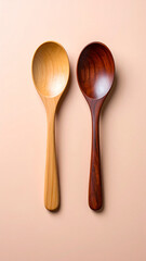 Artistic flat lay of a pair of wooden spoons with different tones and surface textures, on a clean pastel split background