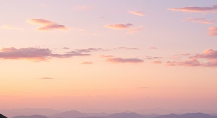 Obraz premium Colorful Sunset Sky with Pink and Orange Clouds Over Mountain Range