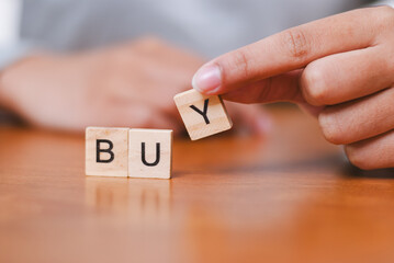 Engaging buying process action indoor table setting close-up perspective hand showcasing word 'buy'...