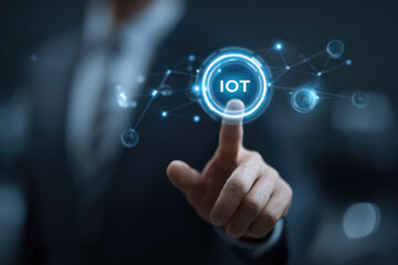 Fototapeta premium Smart business IOT, internet of things concept. Businessman touching IOT icon on virtual screen, connected internet network to access AI intelligence