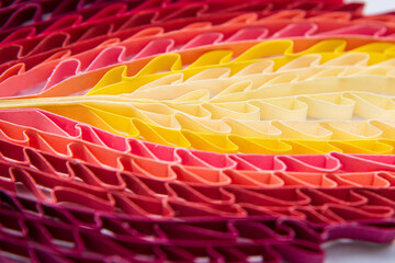 Abstract. Close-up of folded paper arranged in a gradient of colours.