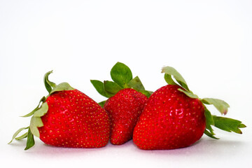 Fresh red strawberries arranged on a plain white background showcasing their vibrant color and...