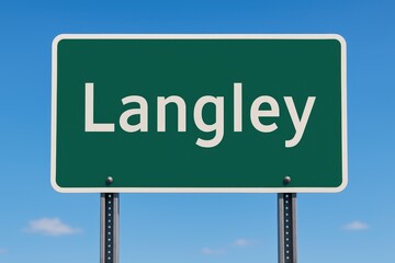 Green road sign displaying "Langley" stands clearly against a bright blue sky, indicating entry or direction to the Canadian city.