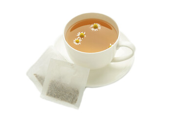 Aromatic herbal tea in white cup and chamomiles isolated on white background.
