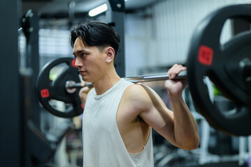 Determined athlete lifting barbell, improving strength and fitness at gym