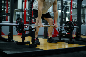 Sportsman lifting weights during strength training in gym
