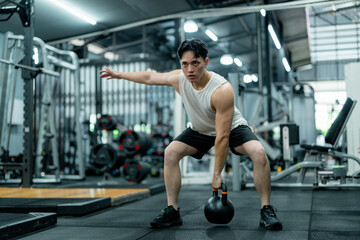 Sportsman exercising with kettlebell in modern gym