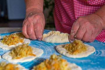 grandmother makes pies with cabbage from dough. High quality photo