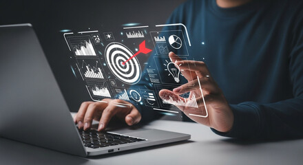 Person using laptop with digital interface showing target and data visualizations overlayed