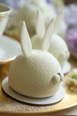 Spring on the table, Easter sweets in the form of rabbits and a porcelain cup, tea or coffee.