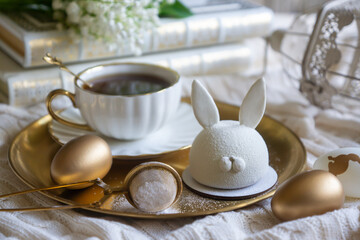 Spring on the table, Easter sweets in the form of rabbits and a porcelain cup, tea or coffee.