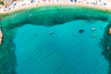 People enjoying turquoise sea and pebble beach in Stara Baška, Krk, Croatia 